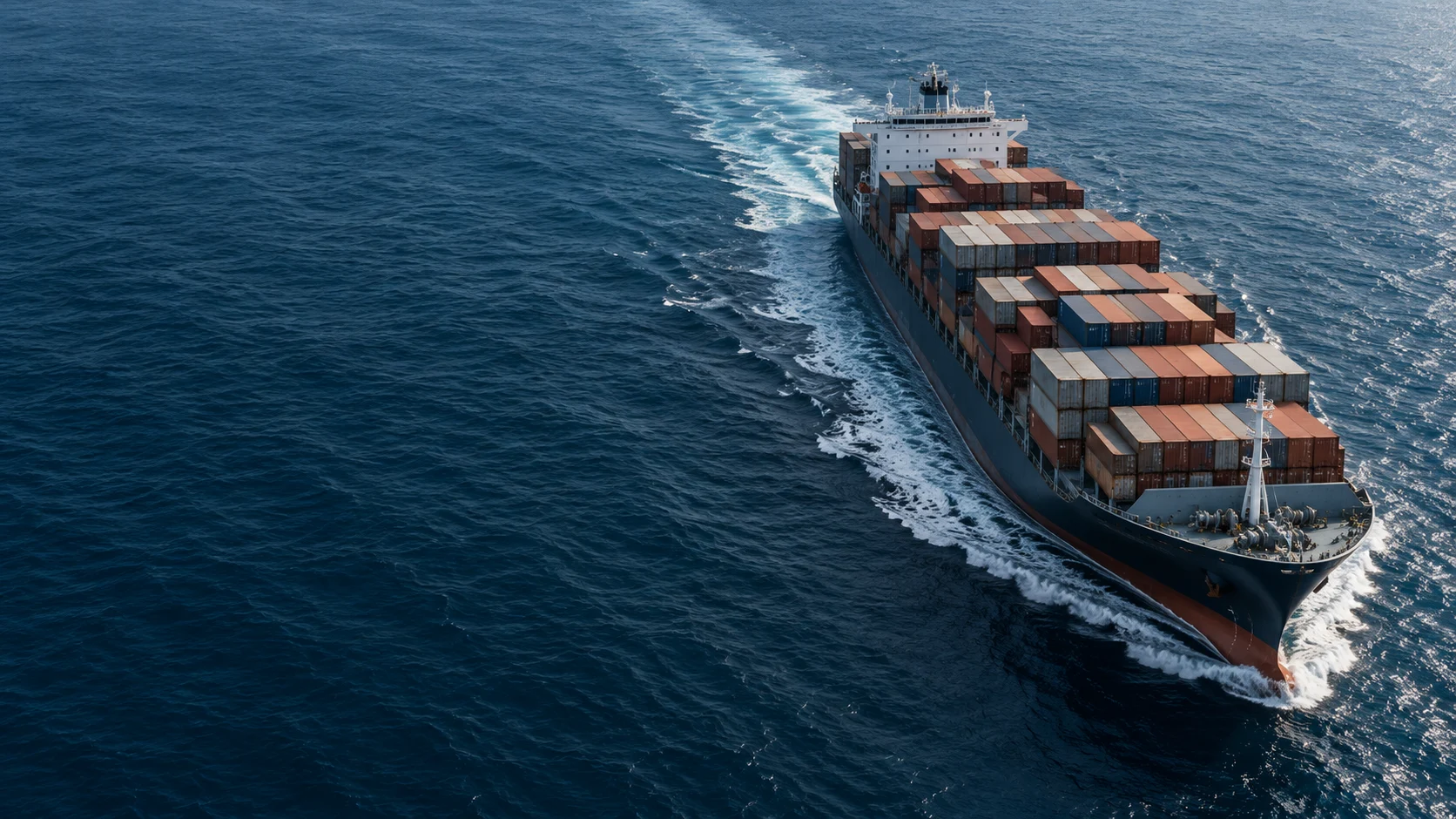 A container ship making its way across deep blue open water